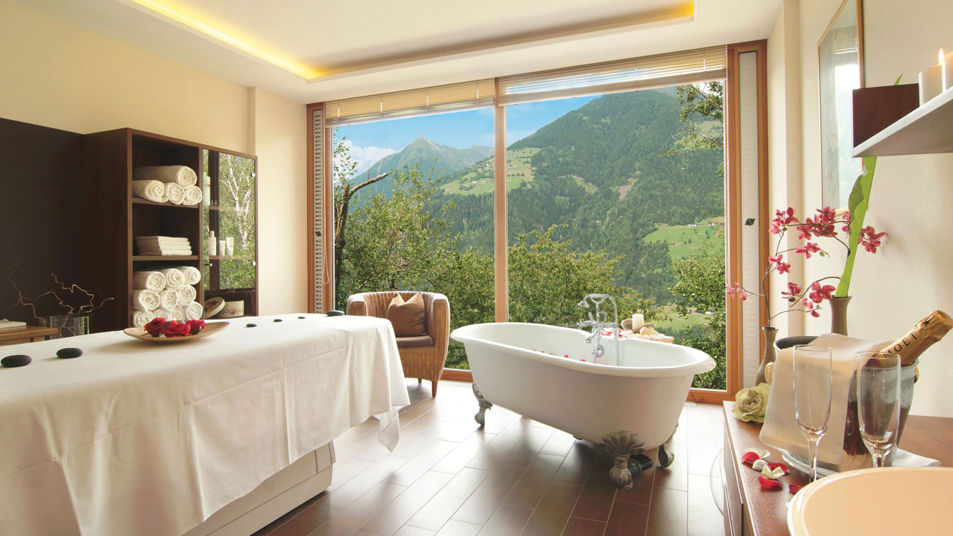 ein Massageraum mit Badewanne und großen Fenstern mit atemberaubender Aussicht auf die umliegende Naturlandschaft