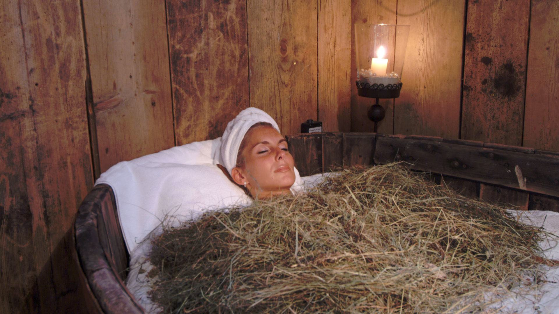 eine Dame während eines Heubads im Verdinserhof